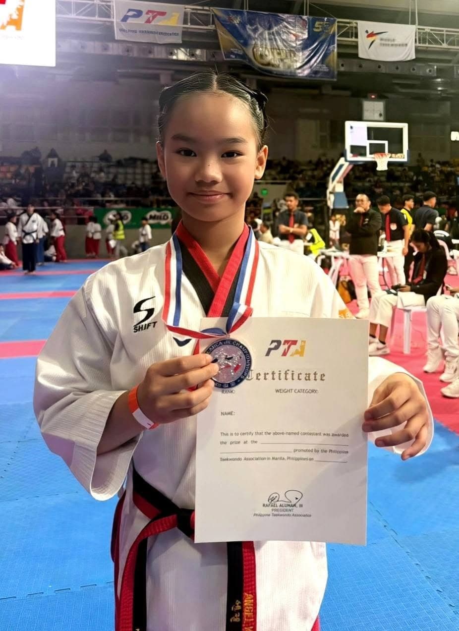A smiling WVT poomsae athlete showing her medal and Philippine Taekwondo Association certificate.