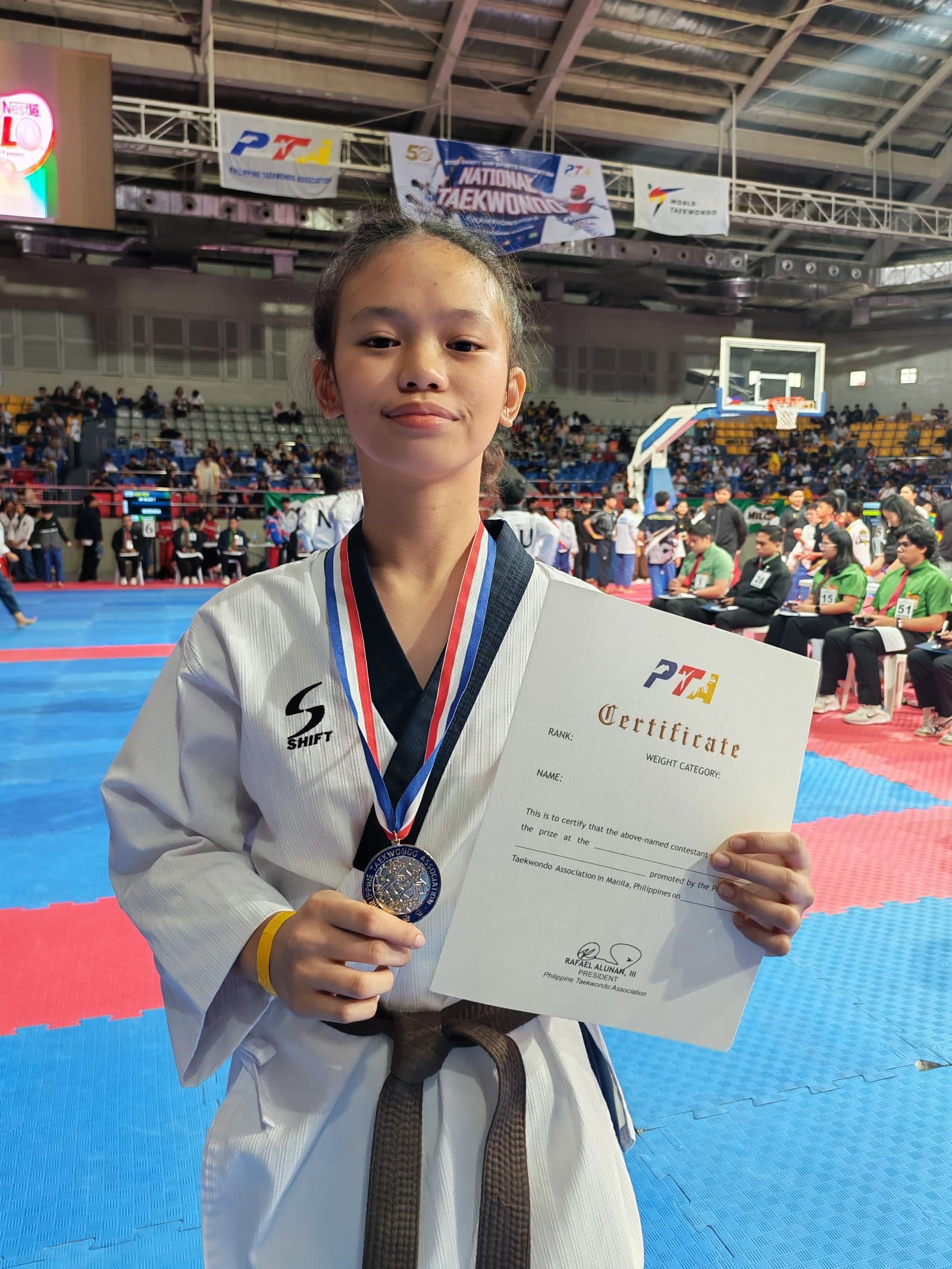 A WVT poomsae athlete with her medal and certificate.