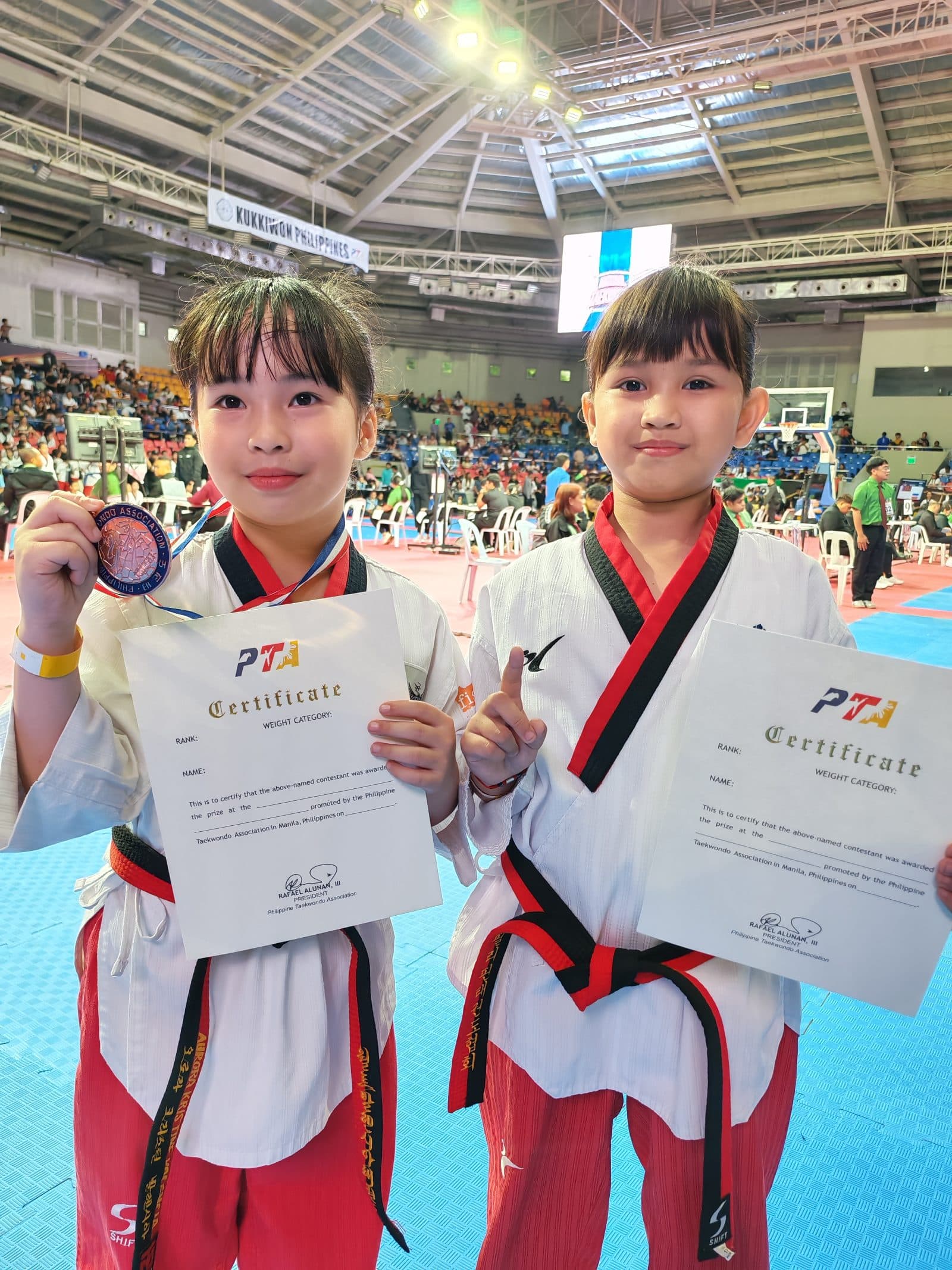 Two WVT athletes showing their medals and PTA certificates.