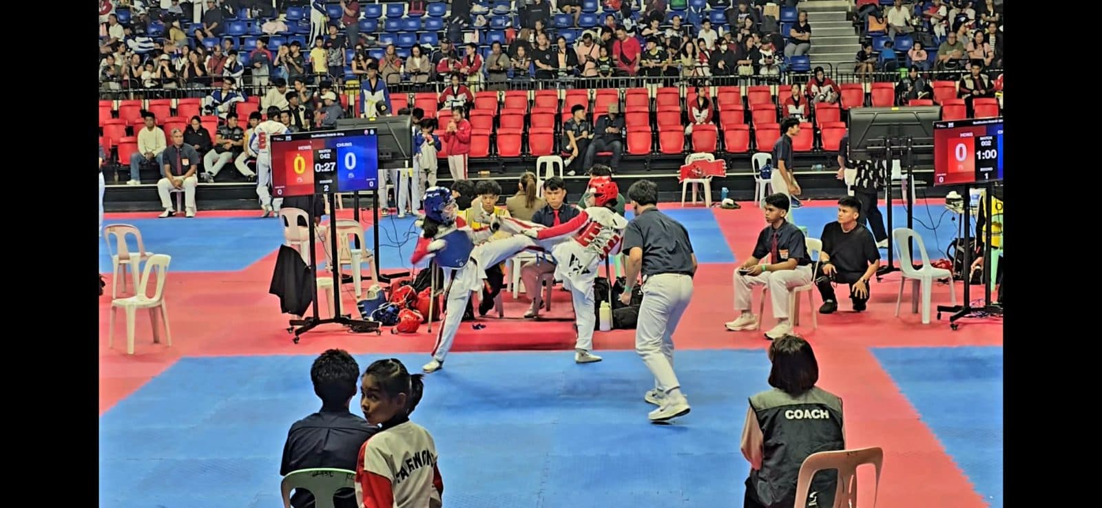 Athletes competing on a red and blue tournament court.